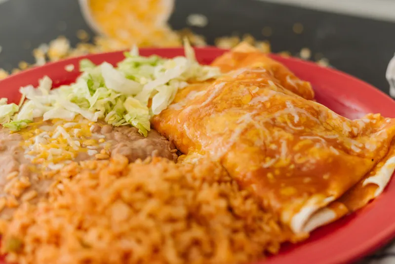 Su Casa's special burrito smothered in enchilada sauce and cheese, served with rice, beans, and lettuce